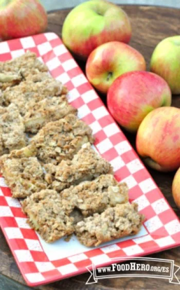 Homemade apple snack bars with oats and nuts on a wooden table