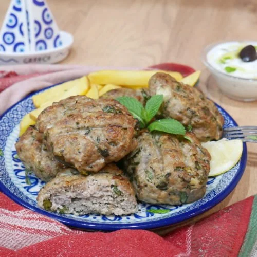Baked beef patties served on a plate with garnishes