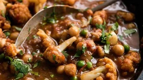 Bowl of Cauliflower Chickpea Curry with spices and herbs