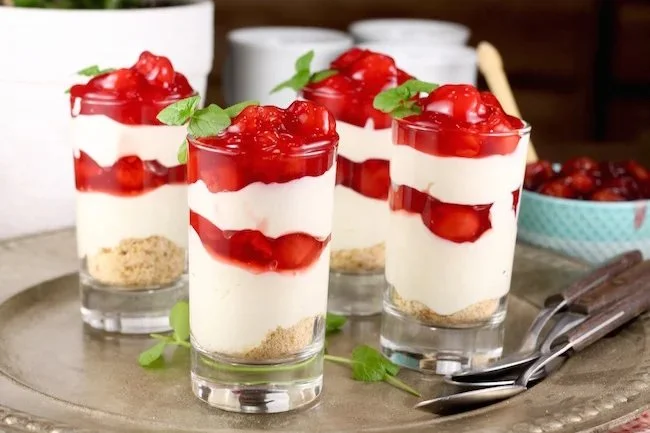 Cherry cheesecake pie shooters served in small cups with cherries on top