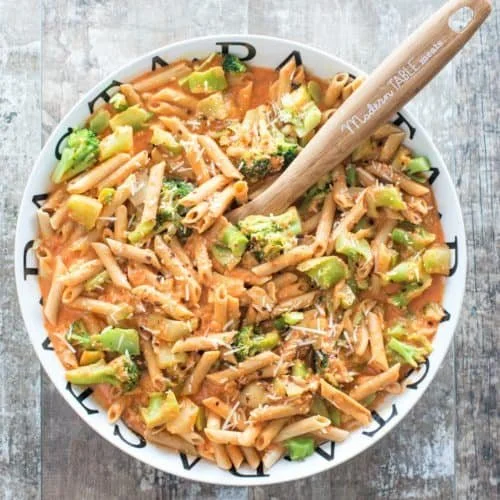 Creamy red pepper lentil pasta topped with fresh herbs and spices.