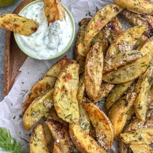 Dill-infused roasted potato wedges served in a rustic bowl.