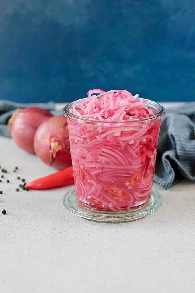Fiery pickled onions in a jar, perfect for enhancing flavors in dishes.