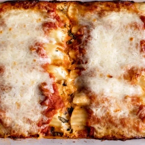 Close-up of homemade manicotti filled with cheese and herbs, ready to serve.