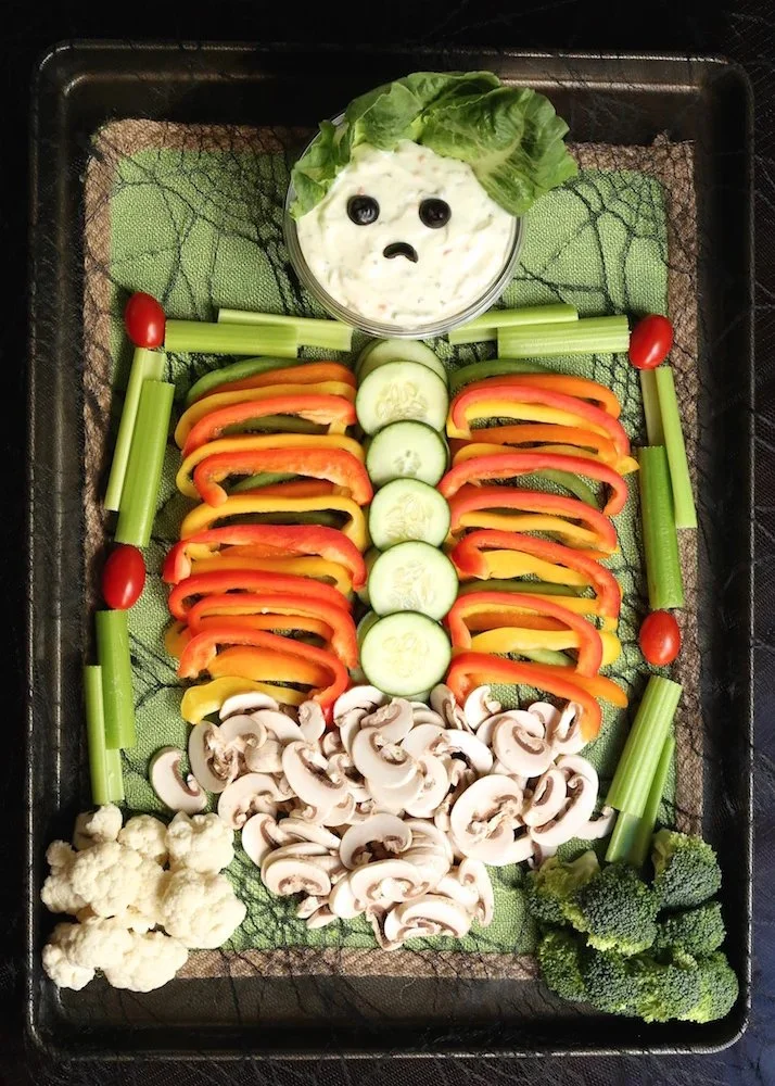 Colorful Halloween veggie tray trio with carrots, celery, and bell peppers.