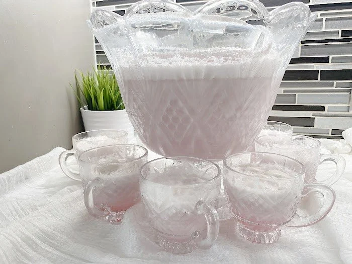 Delicious Ice Cream Punch served in colorful cups with sprinkles and fruit slices.