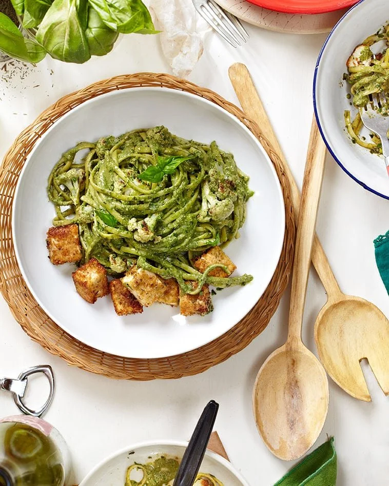 Pesto Cauliflower Pasta topped with crispy breaded tofu, a healthy meal option.
