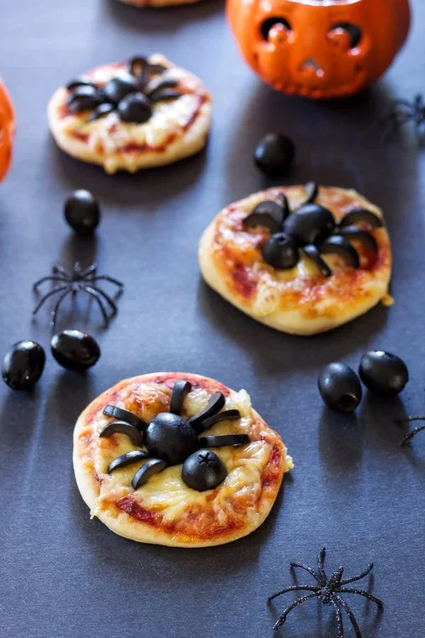 Spider-shaped mini pizzas decorated for Halloween party