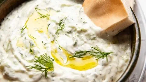 Delicious tzatziki sauce served in a bowl with fresh herbs