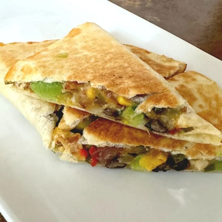 Delicious Ultimate Chicken Quesadilla Stack with melted cheese and chicken