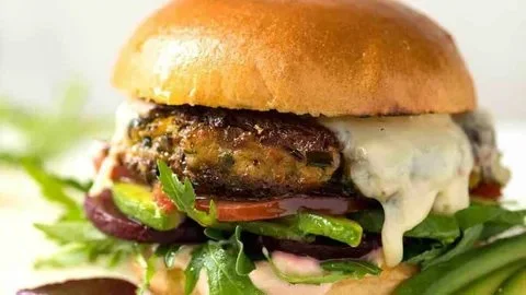 Assorted homemade veggie burgers on a wooden table.